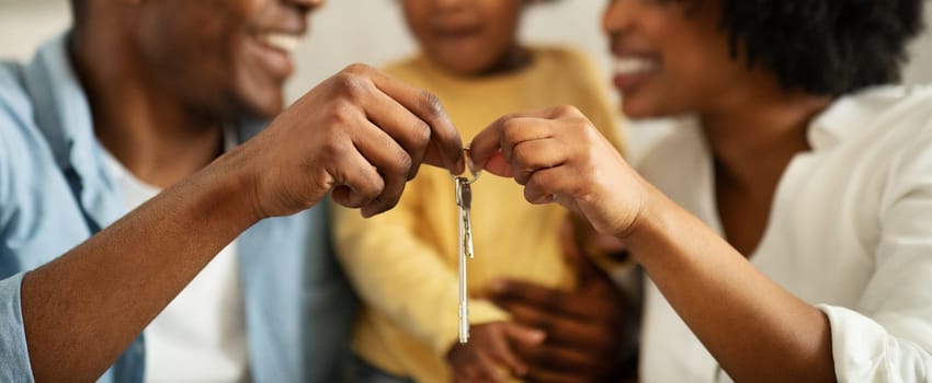 Proud Homeowners. African American Family With Little Daughter Showing Keys And Their Beautiful New Home, Cropped. Happy Parents And Baby Advertising Great Real Estate Offer, Web-banner