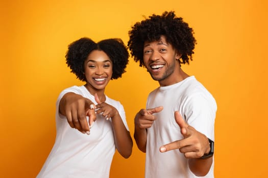 Happy cool millennial african american couple pointing at camera