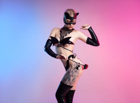 Sexy girl in lingerie, leather cat mask for BDSM, costume for sex games on a pink bright background copy paste