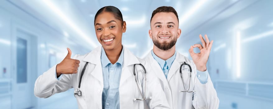 Two cheerful medical professionals in white lab coats are giving a thumbs-up and okay sign