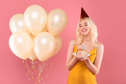 Smiling blonde woman with cake and balloons at birthday party