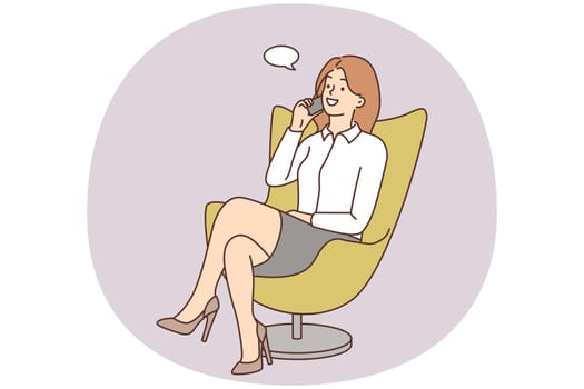 Smiling businesswoman in chair talking on cell