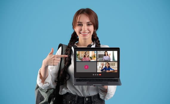A young woman with braided hair and glasses points to a laptop screen