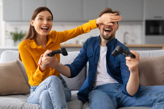 Excited spouses playing video games together at home