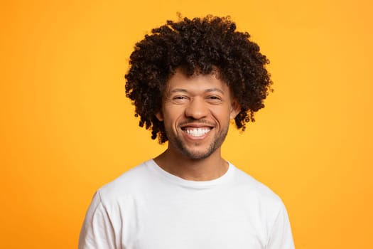 Portrait of handsome young african american man posing on yellow