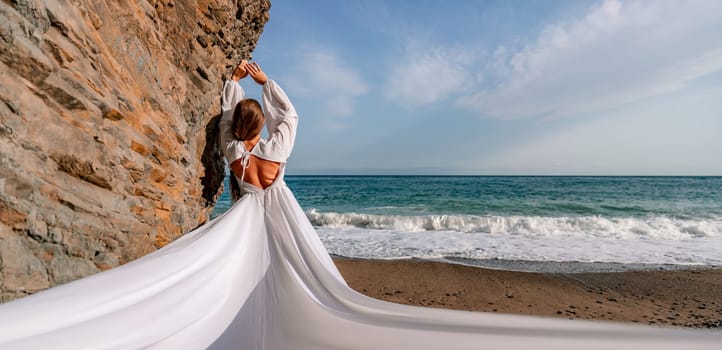 Woman beach white dress flying on Wind. Summer Vacation. A happy woman takes vacation photos to send to friends.