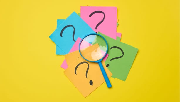 Drawn question marks on stickers and a magnifying glass, yellow background. 