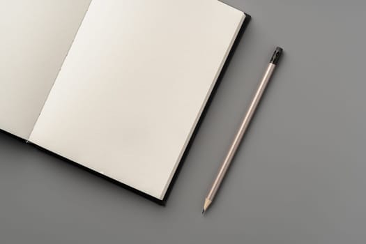 Blank notepad on gray background studio shot