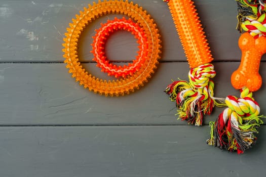Colorful pet toys on gray wooden background