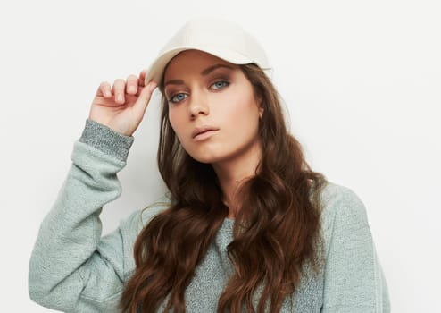 Fashion, portrait and woman with a cap in studio with attitude, confidence or casual style on white background. Trendy, face and female model in cool, edgy or streetwear clothes or outfit choice