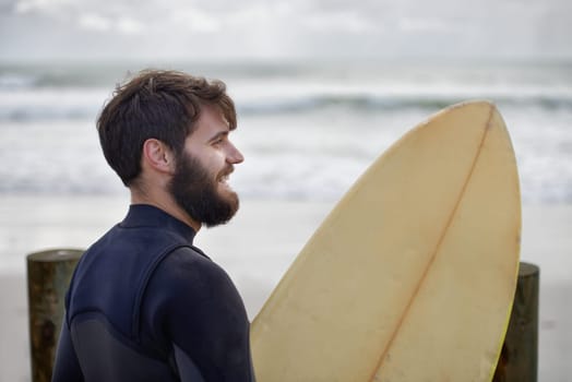 Man, surfboard and exercise at beach on vacation, weekend and sports for fitness in water. Happy male person, hobby and island for ocean waves, wetsuit and traveling on holiday or getaway for peace