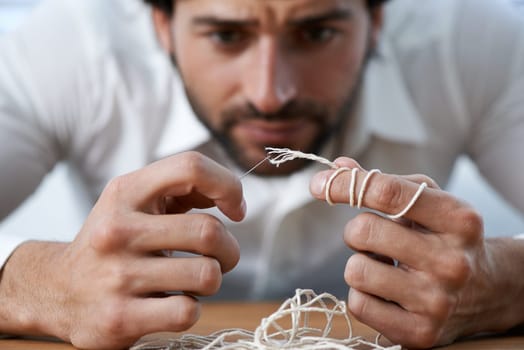 String, thread and man with eye of needle for stitching, sewing and needlework in fashion industry. Struggle, concentration and hands of person with tools for material, textile and tailor business