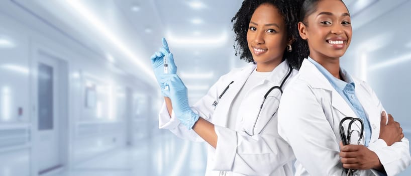 Two confident female medical professionals in white lab coats stand ready