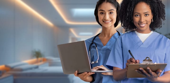 Two female nurses, one holding a laptop and the other writing on a clipboard