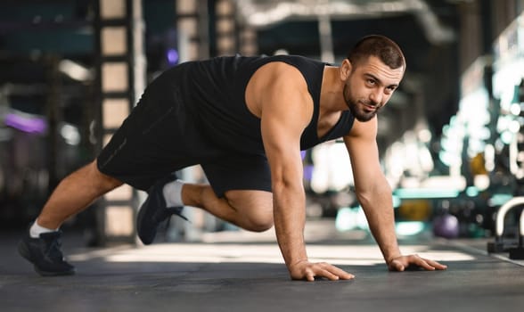 Motivated Muscular Man Making Running Plank Exercise While Training In Gym