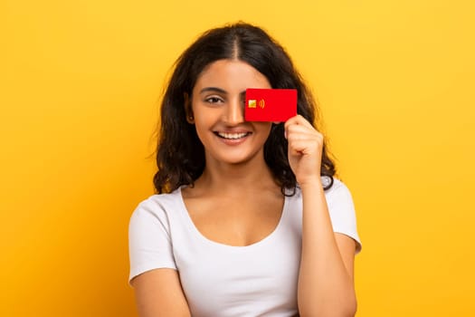 Cute young indian woman cover eye with credit card
