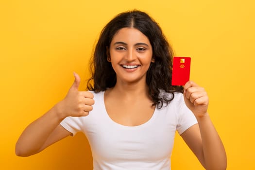 Closeup of smiling indian woman holding plastic debit credit card