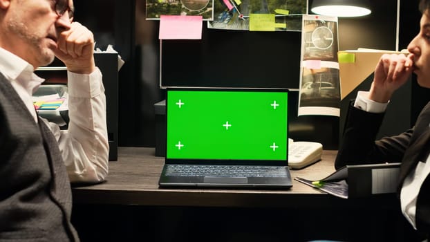Inspectors review greenscreen on laptop