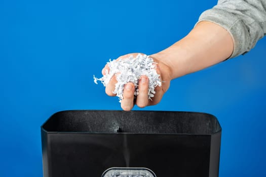 Male hand holding a bunch of shredded paper