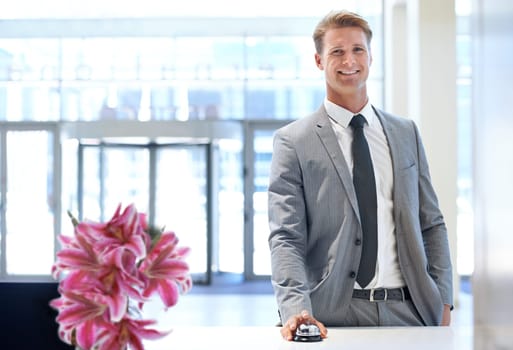 Happy businessman, portrait and bell at reception desk for hotel reservation, stay or check in. Man or employee with smile in stylish business suit at counter for assistance, help or service at lodge