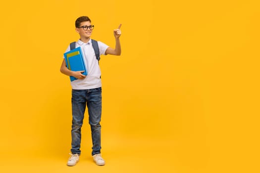 Educational Offer. Smiling Teen Schoolboy Holding Workbooks And Pointing Aside