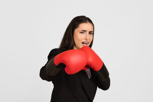 Businesswoman with boxing gloves defending