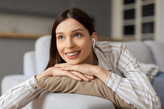 Smiling young woman relaxing at home with content expression