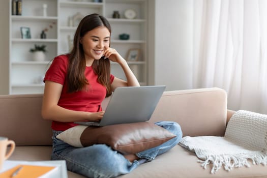 Happy Young Asian Woman Watching Movies Online On Laptop At Home