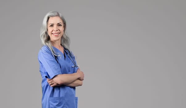 Cheerful nurse woman with crossed arms standing over gray background