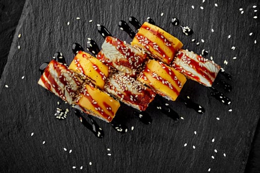 Uramaki rolls wrapped in cheddar and eel with unagi sauce and sesame