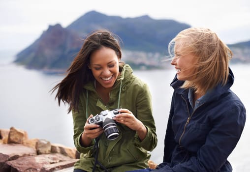 Happy woman, friends and laughing with camera for funny joke, photography or moments together in nature. Female person with smile for photo, picture or memories of fun outdoor holiday or adventure.