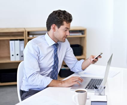 Scroll, office and businessman with phone, laptop and coffee at startup with technology. Browse, online and business analyst at desk with computer, smartphone and internet connection for networking.