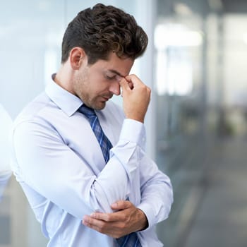 Headache, fatigue and business man with stress, burnout and anxiety for financial crisis in office. Frustrated, depression and serious professional with pain, sick and fail challenge with mistake