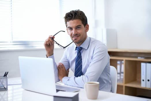 Businessman, portrait and smile at laptop in office with confidence as financial advisor or investment, loan or budget. Male person, face and glasses as broker or online planning, research or funding