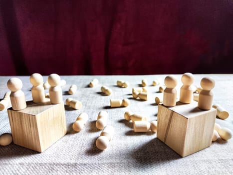 Wooden toys stand opposite and lot of lying figures. Concept of dispute between leaders of two groups. Government and the deaths of citizens and soldiers. War in Russia, Ukraine, Israel, Palestine