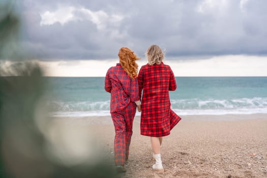 Sea two Lady in plaid shirt with a christmas tree in her hands enjoys beach. Coastal area. Christmas, New Year holidays concep