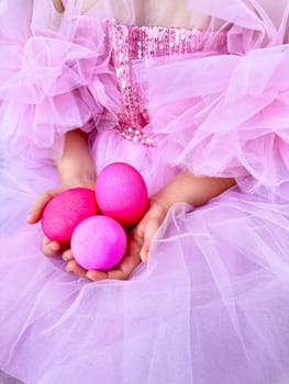 Child in pink tulle dress holding bright pink eggs, Easter celebration concept with a playful and festive feel. For Easter related marketing materials, event invitations, childrens party advertisements.