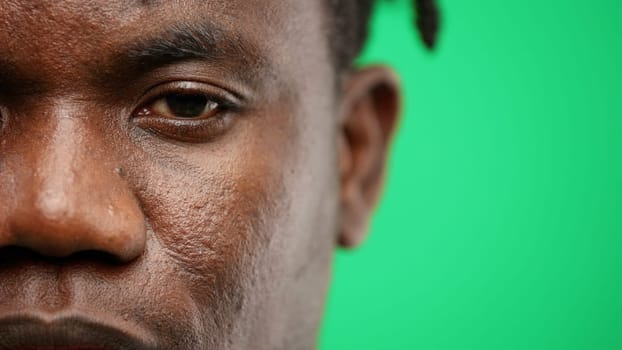 Man's face, close-up, on a green background