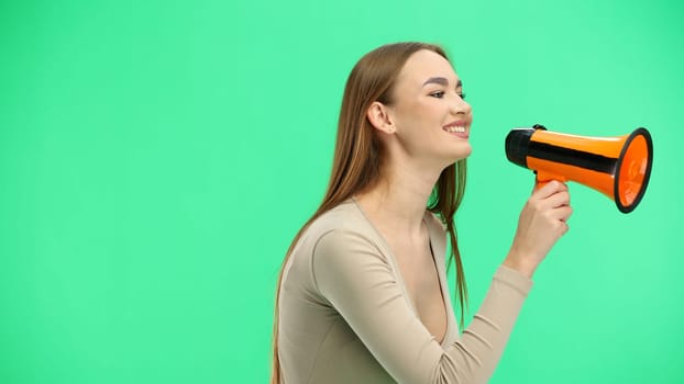 Woman, close-up, on a green background, with a megaphone
