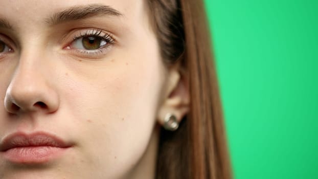 Woman's face, close-up, on a green background