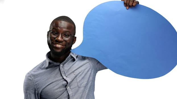 A man, close-up, on a white background, shows a blue comment sign