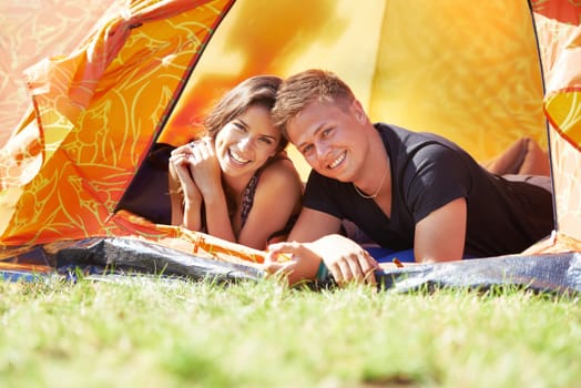 Happy couple, portrait and camping in tent for love, bonding or support on outdoor adventure together. Face of young man, woman or smile for fun holiday weekend, vacation or campsite on green grass