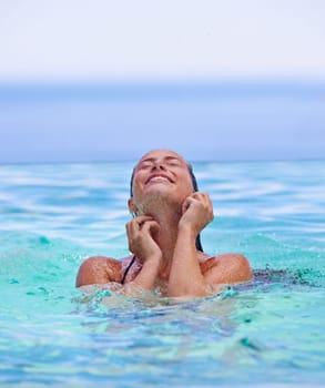 Face, smile and summer with woman in swimming pool for travel, holiday or vacation on blue sky. Tropical, wellness and wet with happy young swimmer person in water to relax at resort for getaway
