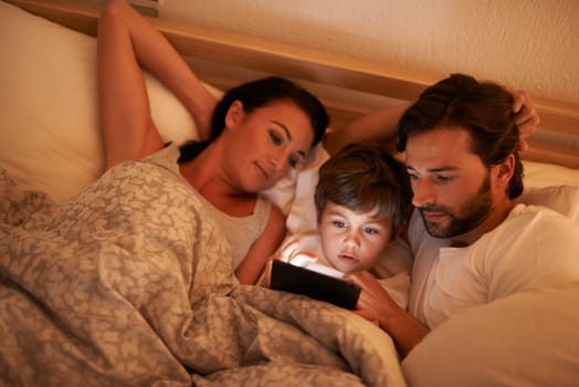 Family, together and movie on tablet in bed, digital and educational for learning of child. Parents, love and technology with connection to internet for bonding, mom and dad relax with son in bedroom