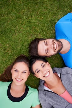 Smile, fitness and portrait of friends on grass for workout, exercise and healthy lifestyle from high angle. Sports, face and happy people outdoors for bonding, connection or break for training.