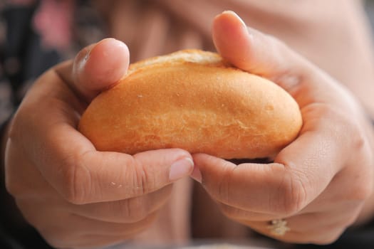 women hand pick baked bun on table