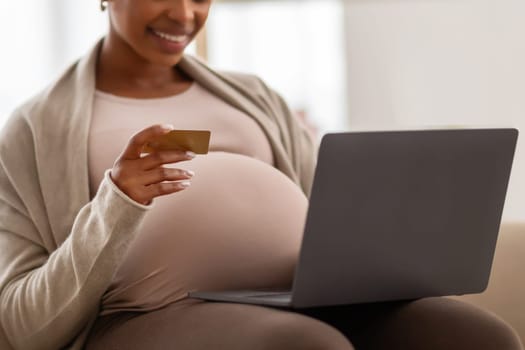 Cropped black pregnant woman mother shopping online for her baby
