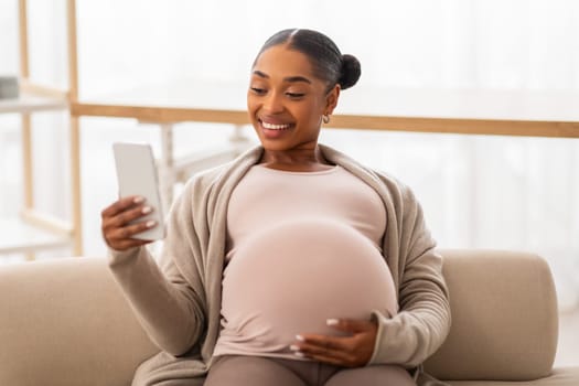 happy lady expecting baby watching funny videos and smiling