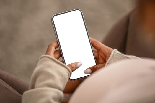 Black pregnant woman holding mobile phone with empty screen mockup