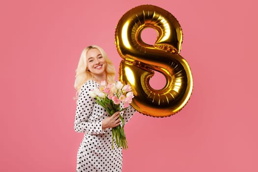 Joyous woman with flowers and golden 8 balloon